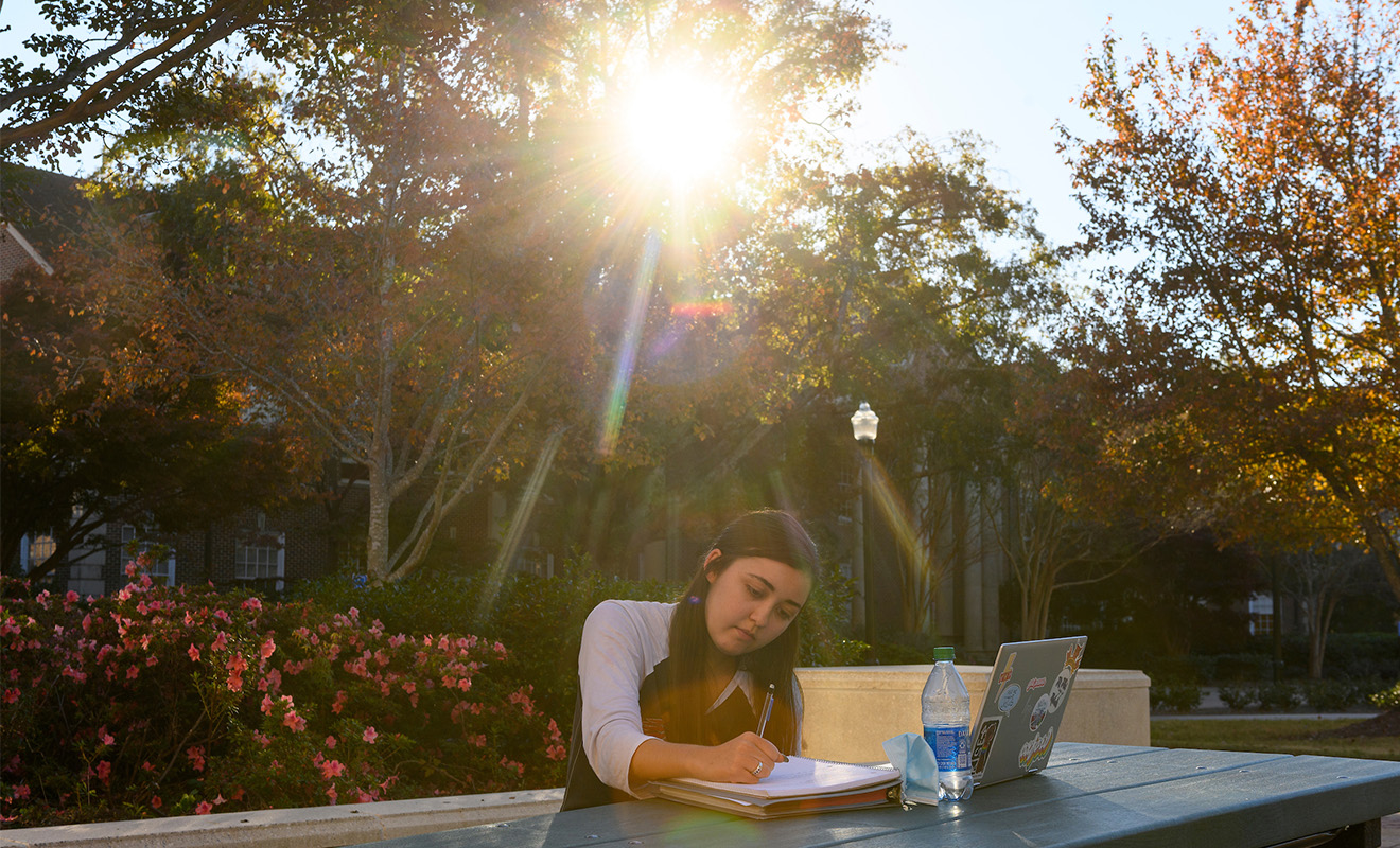 A student studies outside on the University of Mississippi Campus.